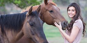 Frau streichelt Pferd auf dem Bauernhof